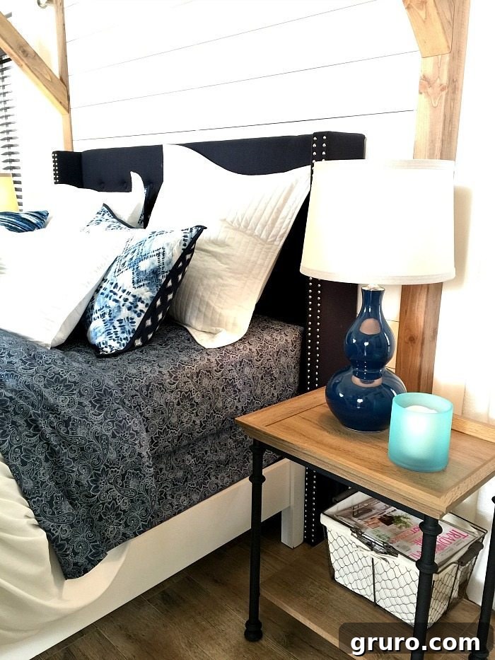 Elegant Navy and White Farmhouse Bedroom featuring a striking shiplap wall and a comfortable padded headboard, showcasing Better Homes & Gardens style from Refresh Restyle.