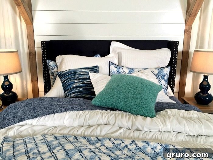 A vibrant pop of turquoise accentuates the classic Navy and White Farmhouse Bedroom, adding playful detail and visual interest, as seen on Refresh Restyle.
