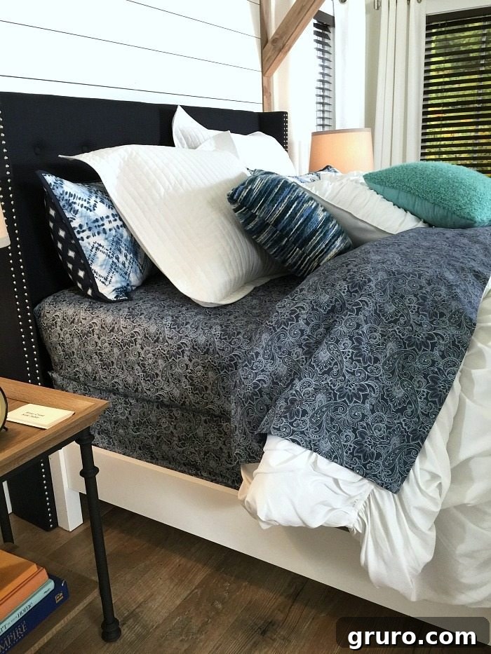 Classic Navy and White colors define this beautiful Farmhouse Bedroom, complete with a shiplap wall and padded headboard, inspiring decor ideas from Refresh Restyle.