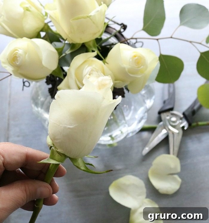 Autumn Glow Centerpiece 5 Trimming white roses for a low-profile fall floral arrangement in a pumpkin vase