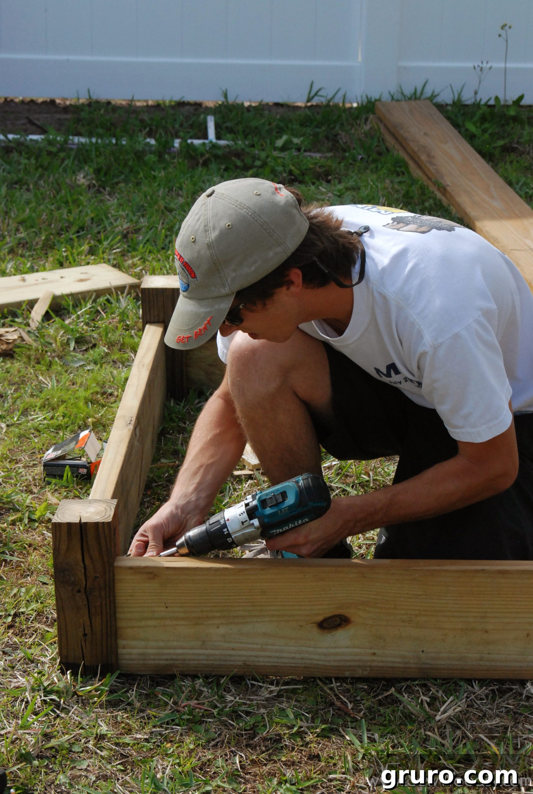 Mr. Woodsy cutting a 2x8 board to length with a circular saw for the raised garden bed sides.