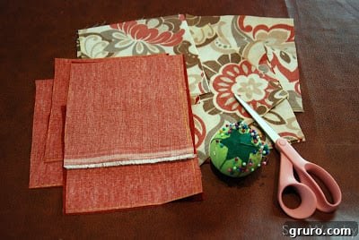 Fabric squares, thread, scissors, pins, and feed corn laid out for making bean bags