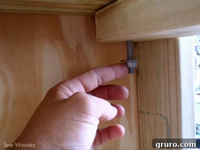 Attaching a rounded leg to the cornhole board frame with a carriage bolt
