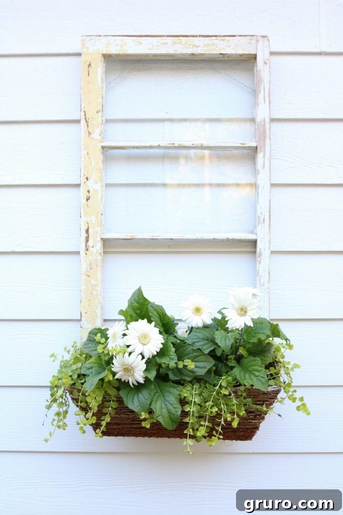 This repurposed old window with a planter box would look fantastic hanging in a bathroom, holding rolled towels instead of plants, offering a touch of rustic spa elegance.