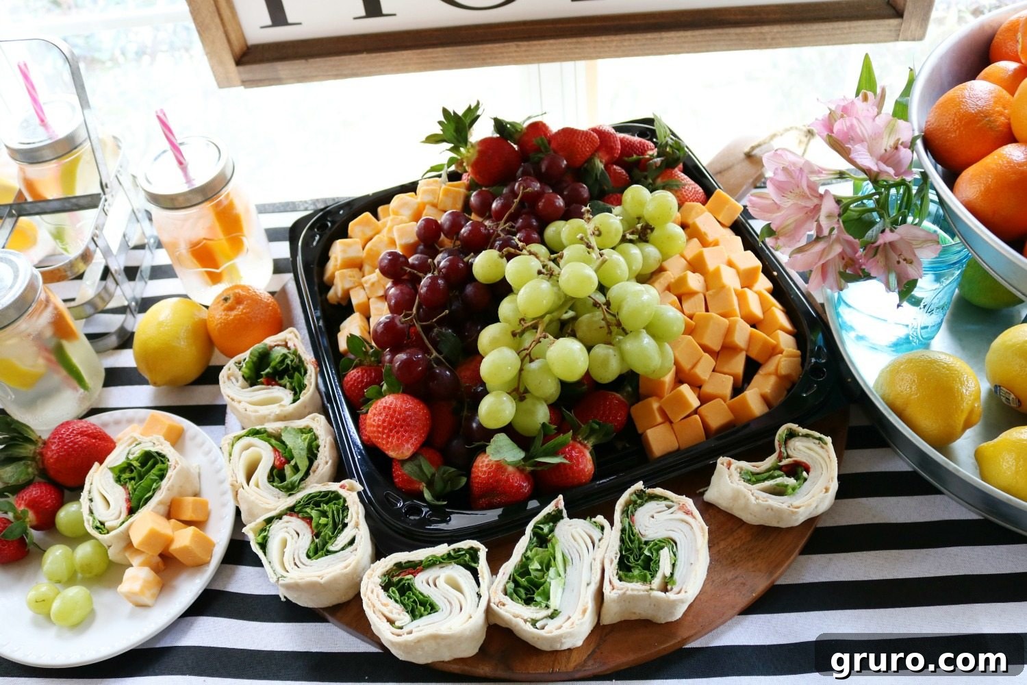 Colorful fruit and spiral turkey sandwiches beautifully arranged for a spa party, offering healthy and appealing snacks.