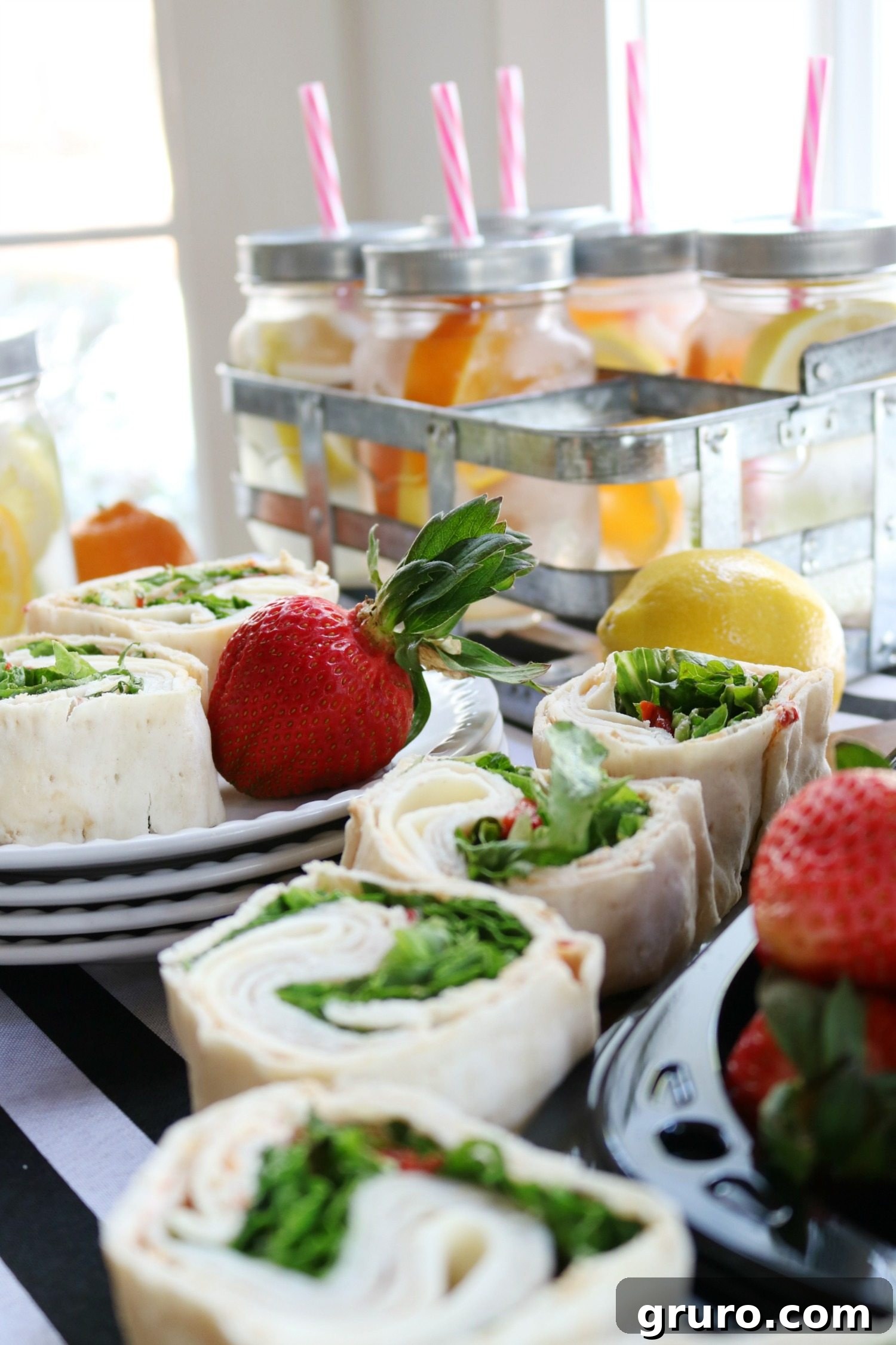 A refreshing spread of fruit-infused water and savory wraps, ideal for a light and healthy spa party menu.