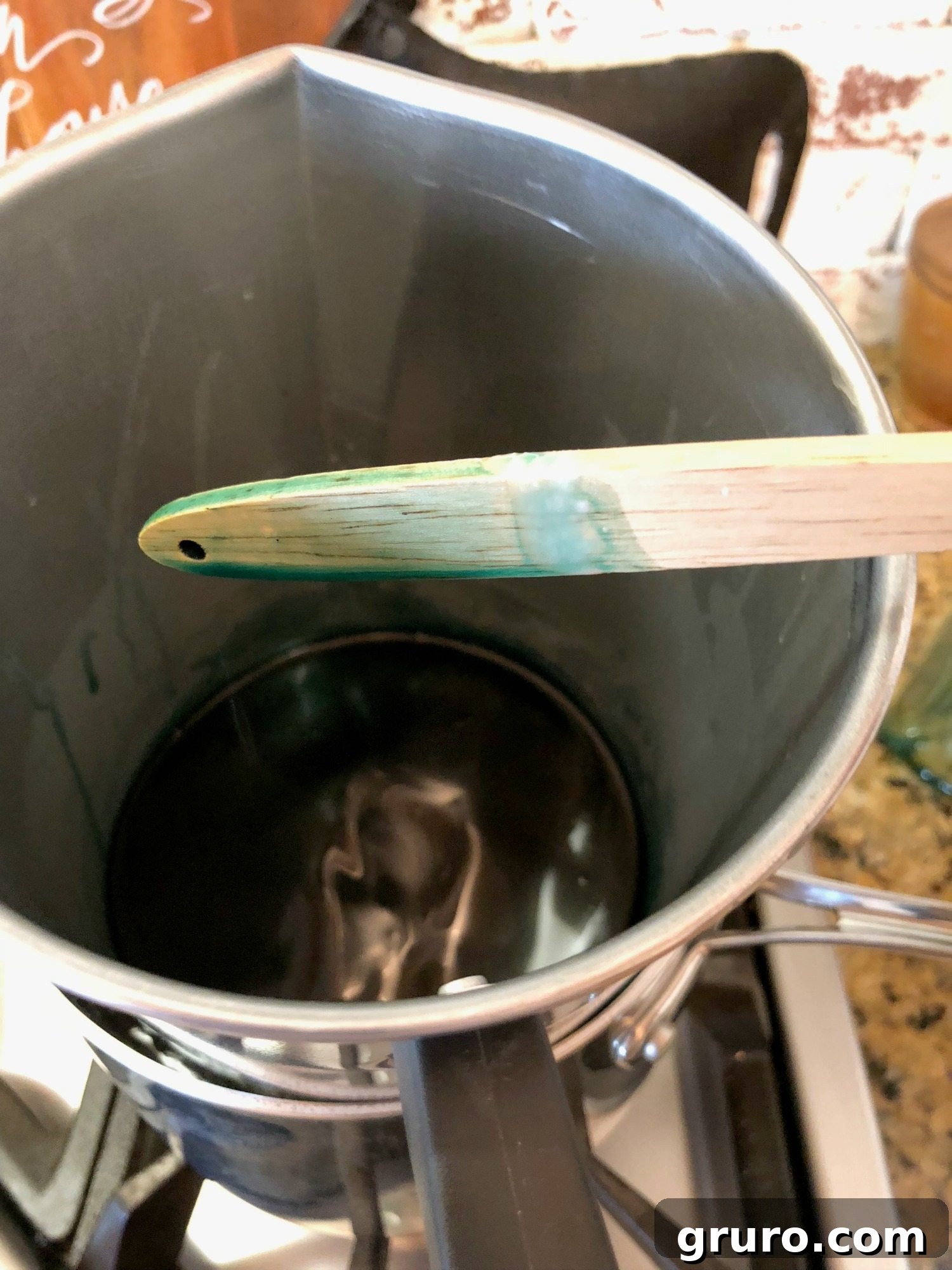Adding wax colorant to melted candle wax to achieve a desired shade