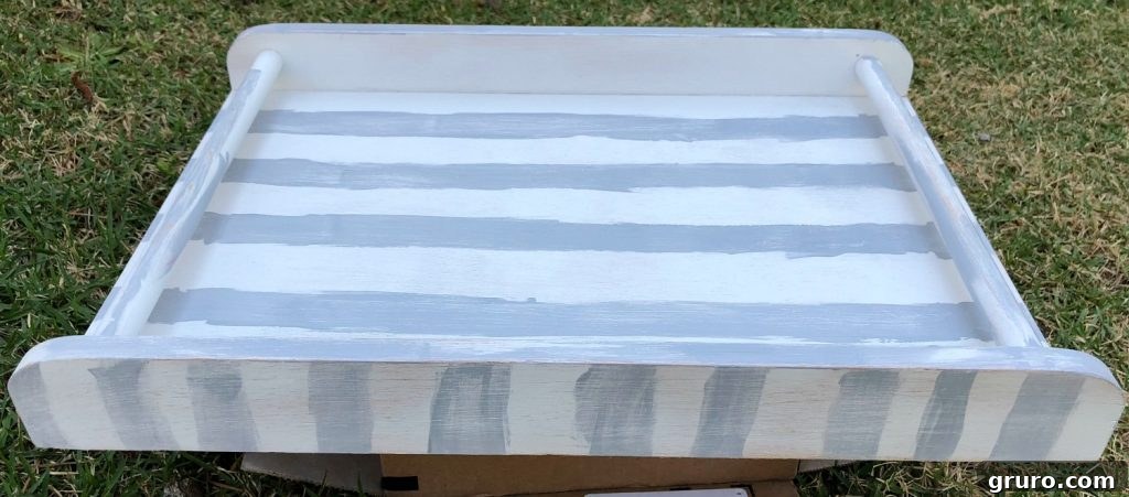 Applying stripes to the thrift store tray with craft paint.