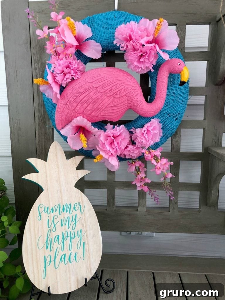 Completed DIY flamingo wreath, featuring a pink flamingo and vibrant flowers, ready for summer display