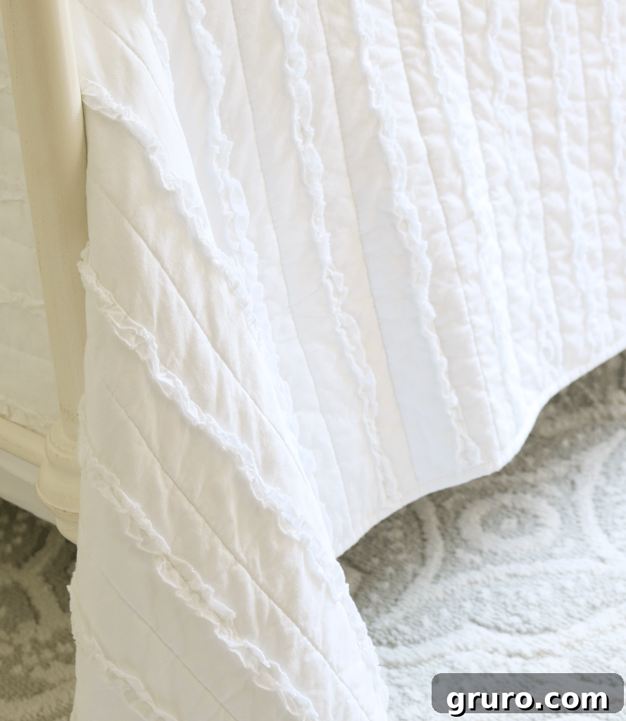 Close-up of the ruffled farmhouse quilt from Better Homes & Gardens, adding texture and softness to the bed
