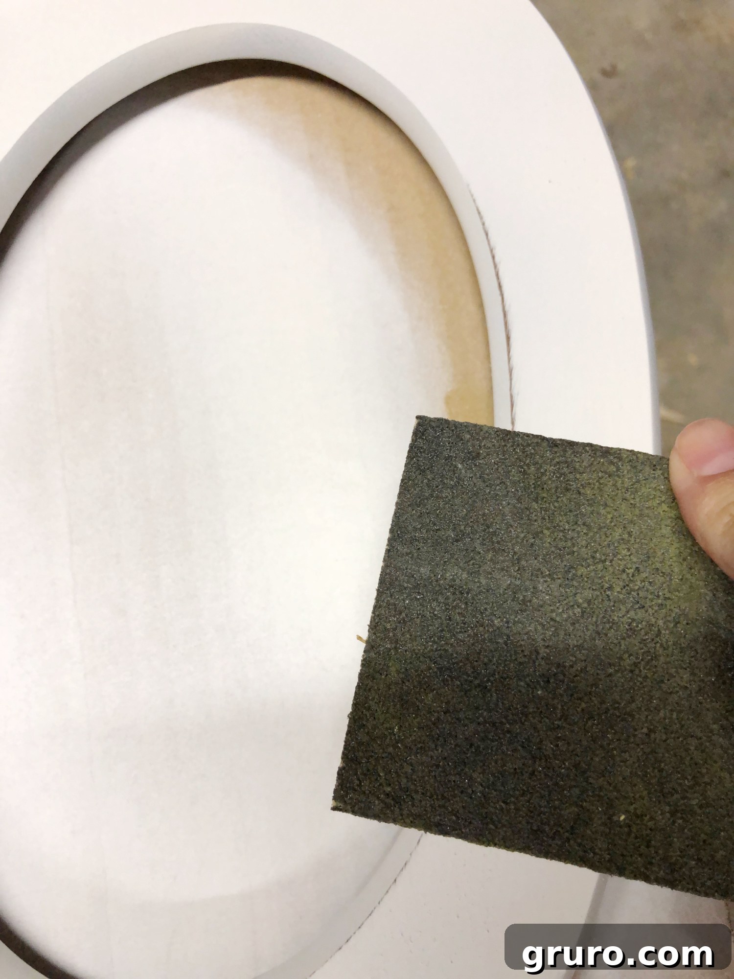 Chalk painted mirror stand piece being sanded