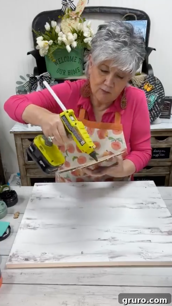 Applying hot glue to the back of the butterfly cutout