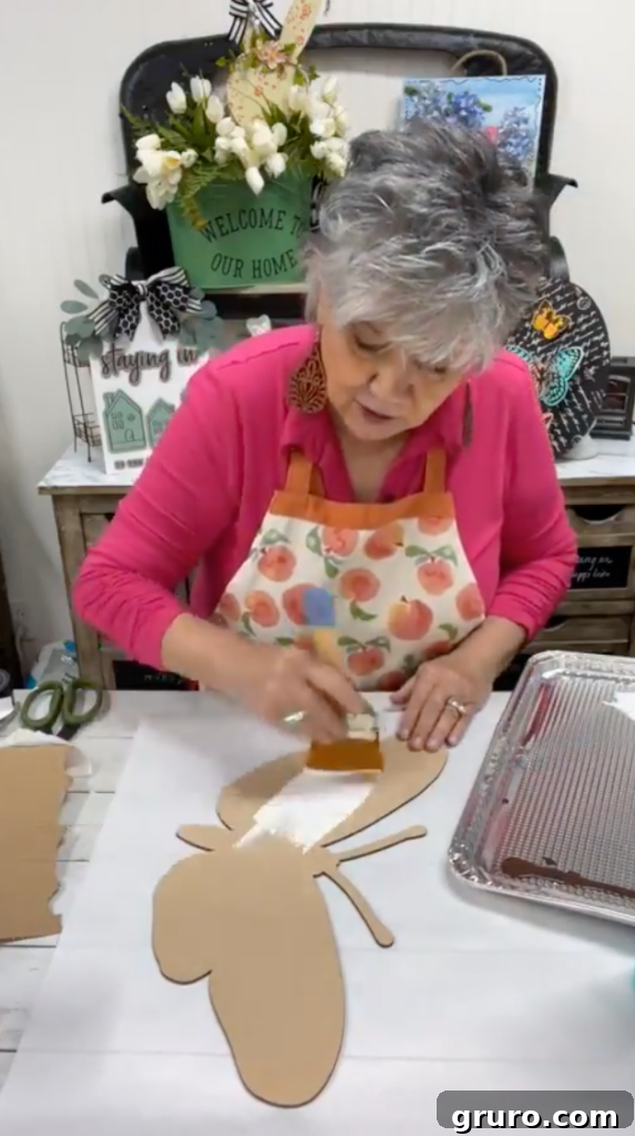Adding green paint to the butterfly wood cutout