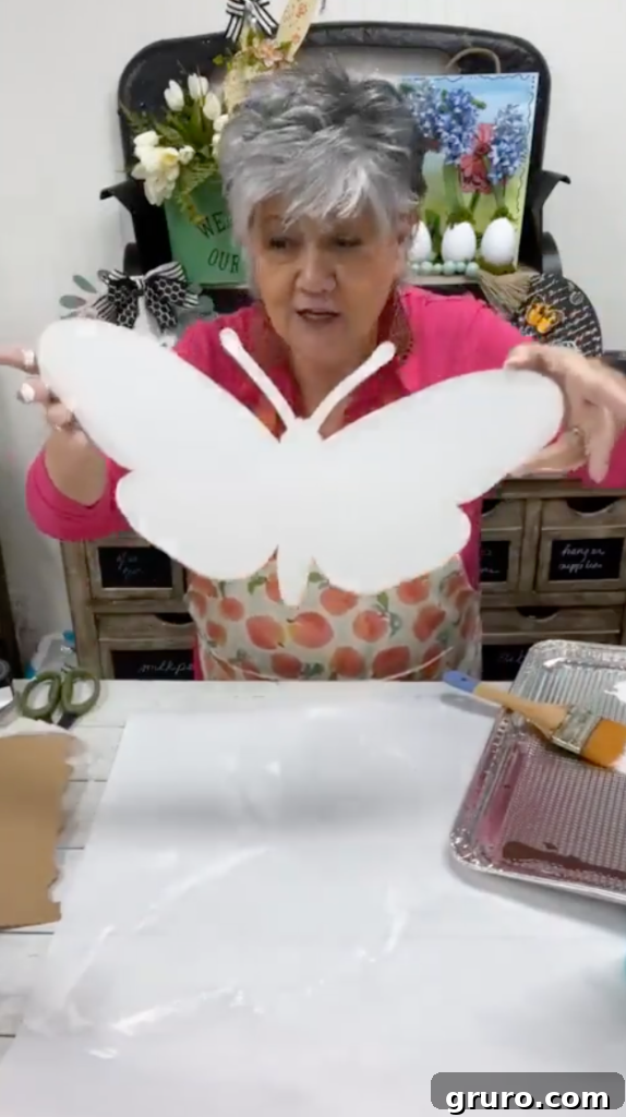 Blending orange and green paints on the butterfly cutout