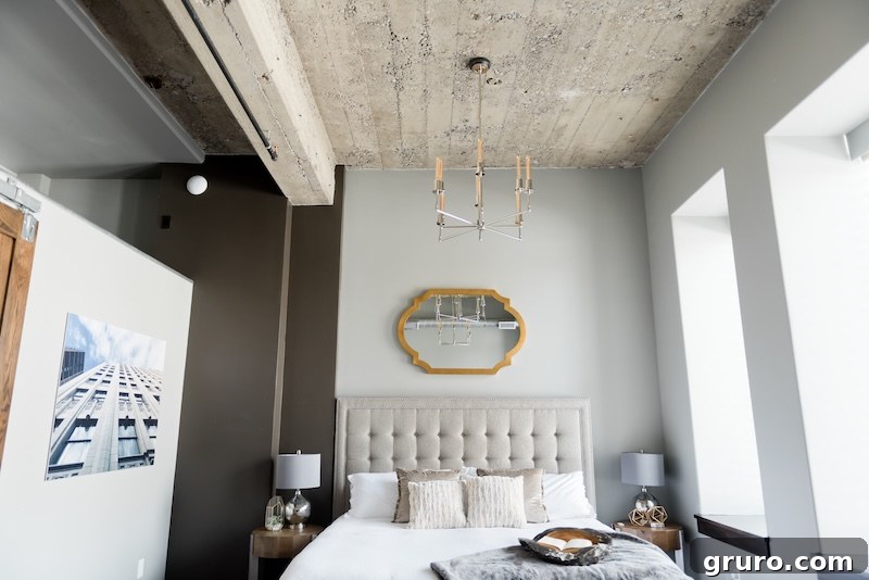 Modern farmhouse bedroom with soft gray walls, wooden bed frame, and white bedding