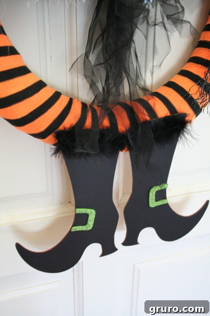 Detailed view of the witch boots securely attached to the Halloween wreath, showcasing the seamless integration with the tights-wrapped base