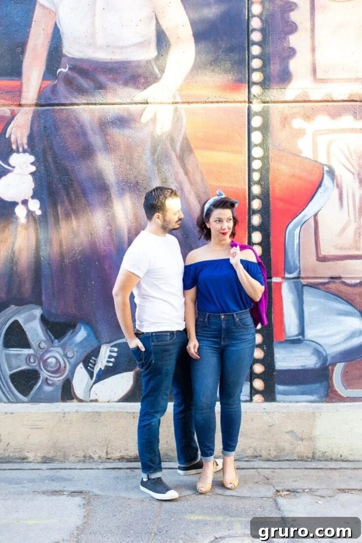 A couple dressed in Couples Greaser Halloween Costumes, featuring 1950s rock 'n' roll style with leather jackets and slicked-back hair.