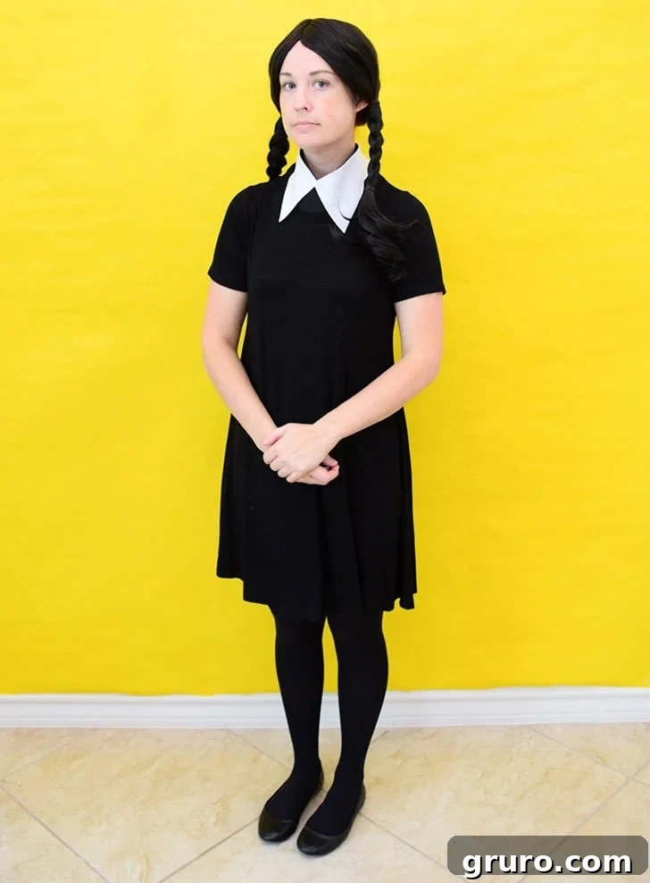 A couple dressed as Wednesday and Pugsley Addams from the iconic Addams Family, with their signature eerie attire.