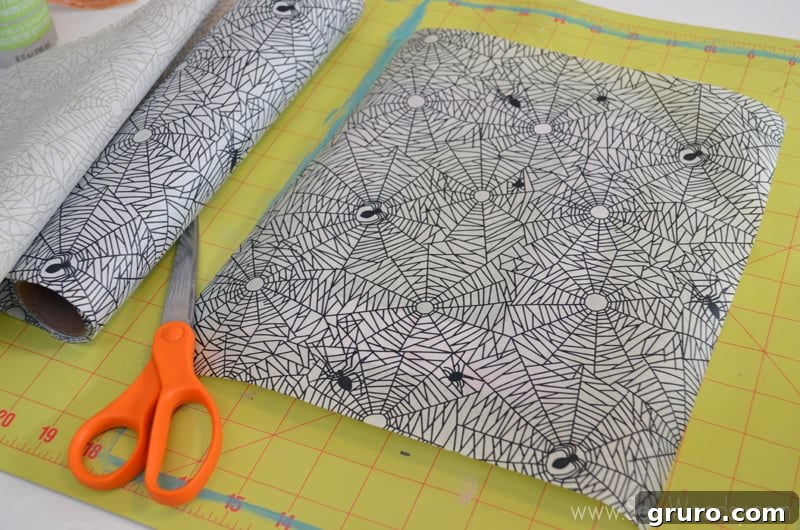 Decoupage Spider Web Picture Frame supplies laid out: wood frame, Martha Stewart Crafts decoupage, foam brush, spider decoupage paper, scissors, 3D spider stickers. Perfect for Halloween crafting.