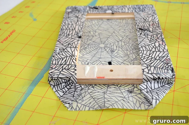 Applying a light coat of Martha Stewart Crafts Glow In the Dark Decoupage glue to the back edges of the wood frame.