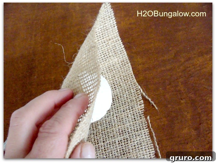 Image showing how to fold fabric over the styrofoam ball to estimate the size for the snowman's hat.