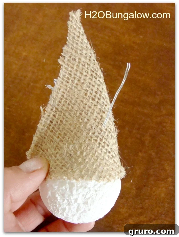 Image showing the hat placed on the snowman's head, with the wire hanger poked through the top, ready for final assembly.