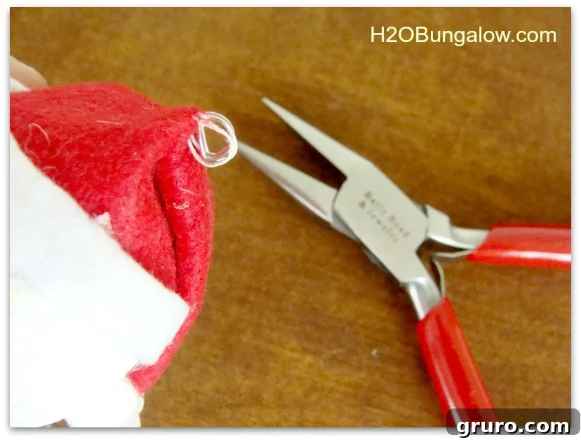Image showing how to twist the wire sticking out of the hat into a loop using pliers to create a hanger for the ornament.