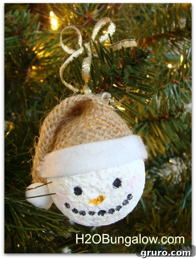 Finished DIY snowman ornament with a red felt hat, ready to hang on a Christmas tree.