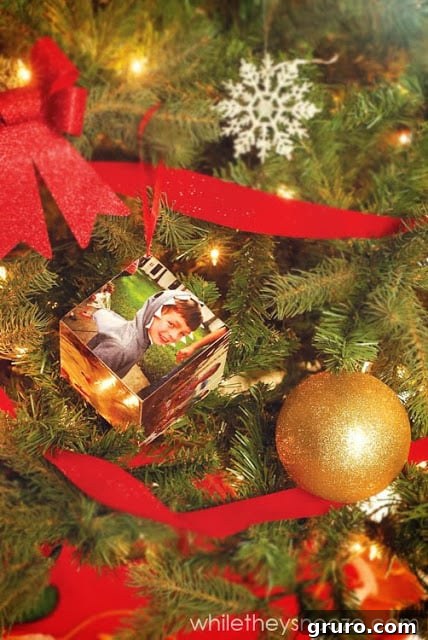 A close-up of the handcrafted Instagram Time Capsule Ornament nestled among other festive decorations on a Christmas tree.