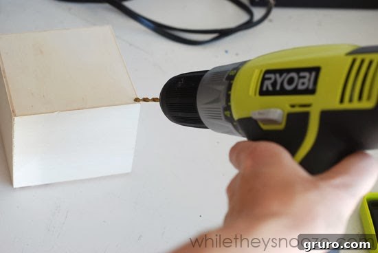 Drilling a small hole in the corner of a wooden trinket box for the ornament hanger.