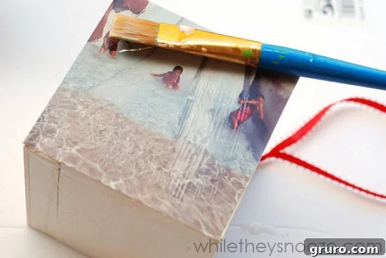 Smoothing down an Instagram photo onto the wooden box, ensuring a wrinkle-free finish with Mod Podge.