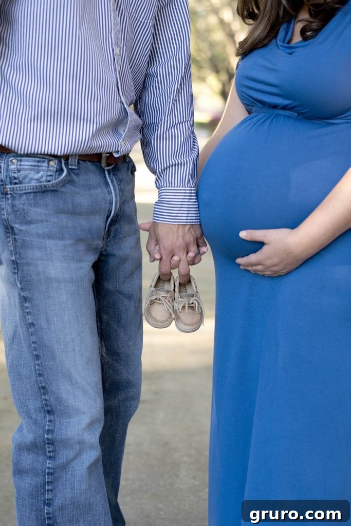 Expectant mother holding tiny baby shoes, heartwarming maternity photo