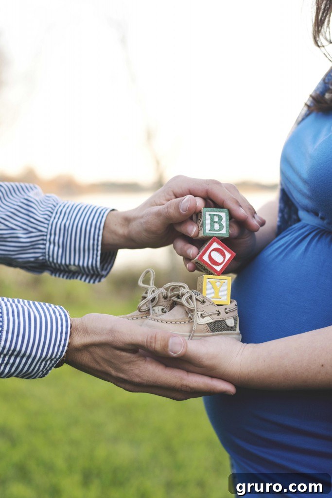 Maternity photo holding baby shoes and blocks, symbolizing new beginnings