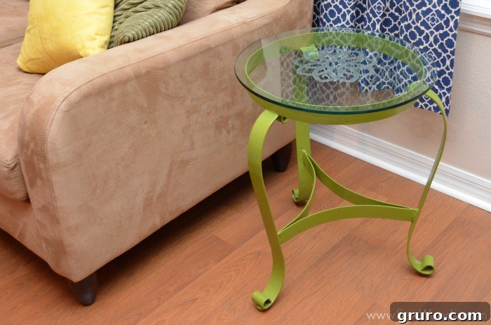 A beautifully upcycled glass end table with an etched floral design, in a living room setting