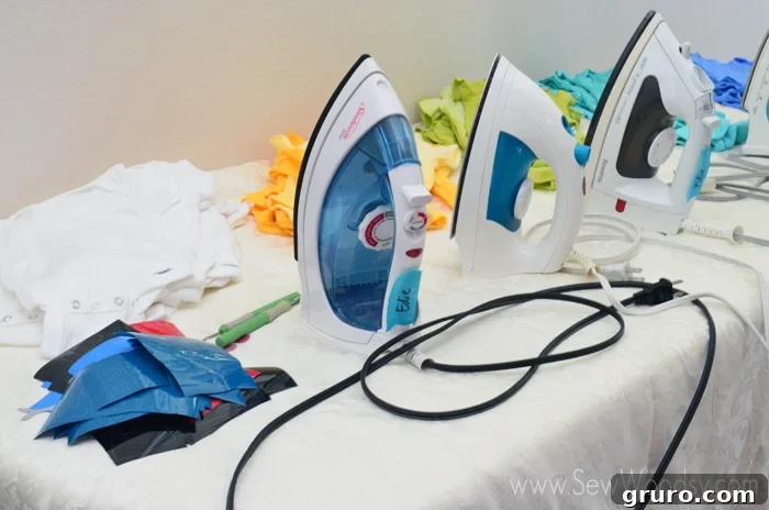 A selection of colorful onesies and vinyl designs organized for a baby shower activity