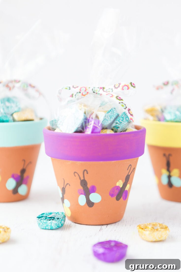 A decorative flower pot adorned with colorful thumbprint butterflies, a charming and child-friendly craft for Mother's Day.