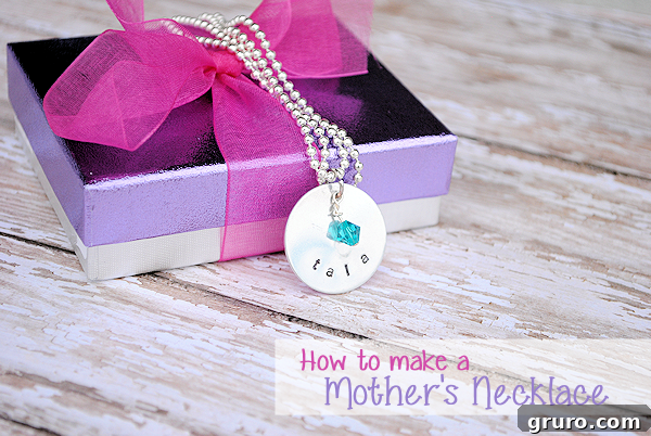 A close-up of a hand-stamped Mother's necklace, featuring personalized charms with initials or names, a meaningful and trendy gift.
