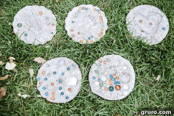 Personalized DIY concrete stepping stones adorned with handprints, footprints, or mosaic designs, perfect for a garden path.