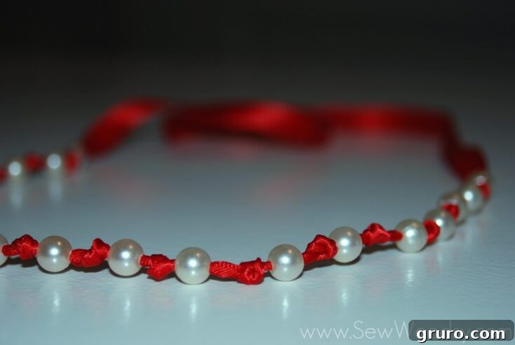 An elegant pearl ribbon necklace, featuring lustrous pearls strung along a delicate ribbon, a beautiful and classic accessory.