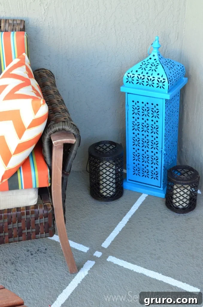 Beautifully painted tan patio floor with white square pattern, adorned with a blue lantern and a stylish couch.