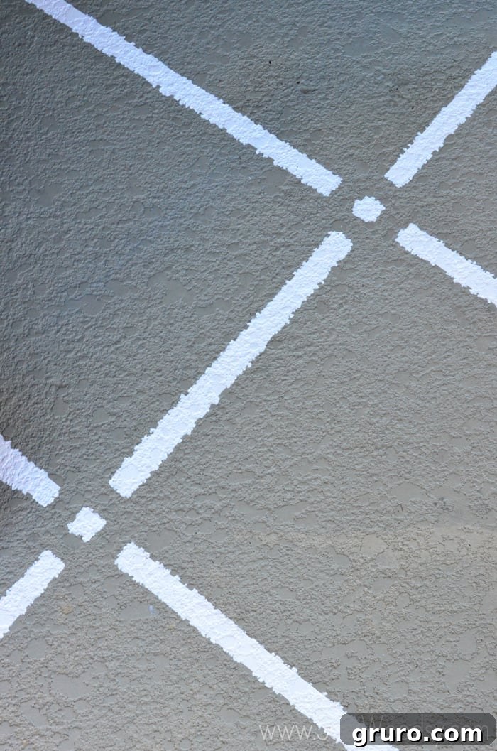 Close-up detail of the clean, stripped paint pattern on a concrete pad, showcasing the texture and crisp lines.