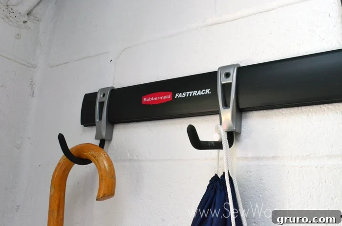 Various garden tools and cleaning supplies neatly hung on Rubbermaid FastTrack hooks