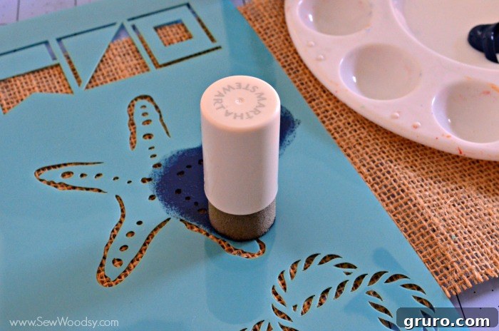 Rustic Sea Star Craft 6 Detailed image of a crafter carefully pouncing Martha Stewart Wild Blueberry paint onto the starfish stencil placed on burlap fabric, creating the DIY Burlap Starfish Art.