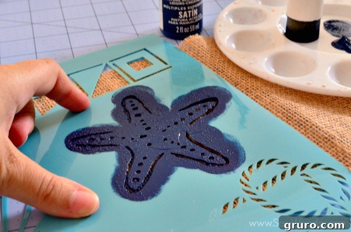 Rustic Sea Star Craft 7 Close-up shot emphasizing the technique of holding the stencil firmly with one hand while pouncing paint with the other, ensuring no movement for a clean Burlap Starfish Art design.