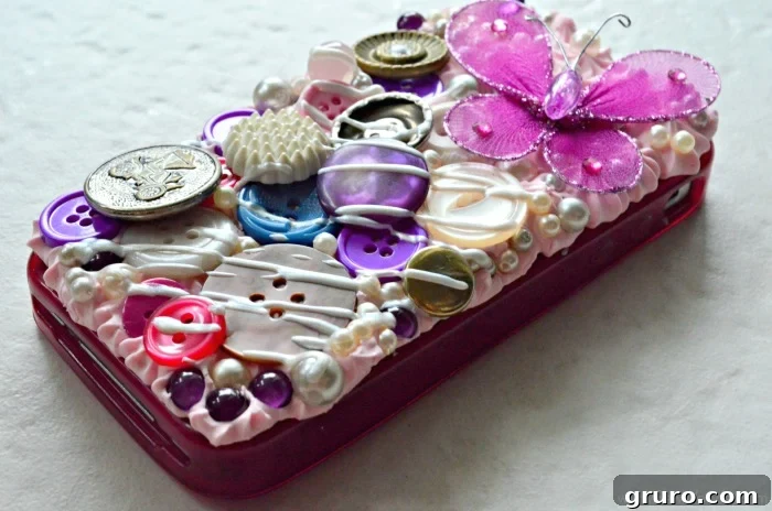 A close-up shot of the finished Decoden phone case, highlighting the vibrant blend of buttons, pearls, and purple stones meticulously arranged on a pink whipped clay base. The image captures the rich texture and colorful aesthetic, showcasing a unique, handcrafted accessory. #plaidcrafts #modpodge
