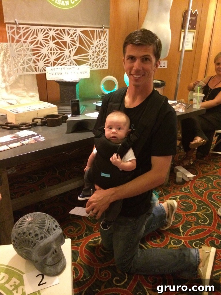 Jon babywearing Ryder while voting on concrete pieces at a booth.
