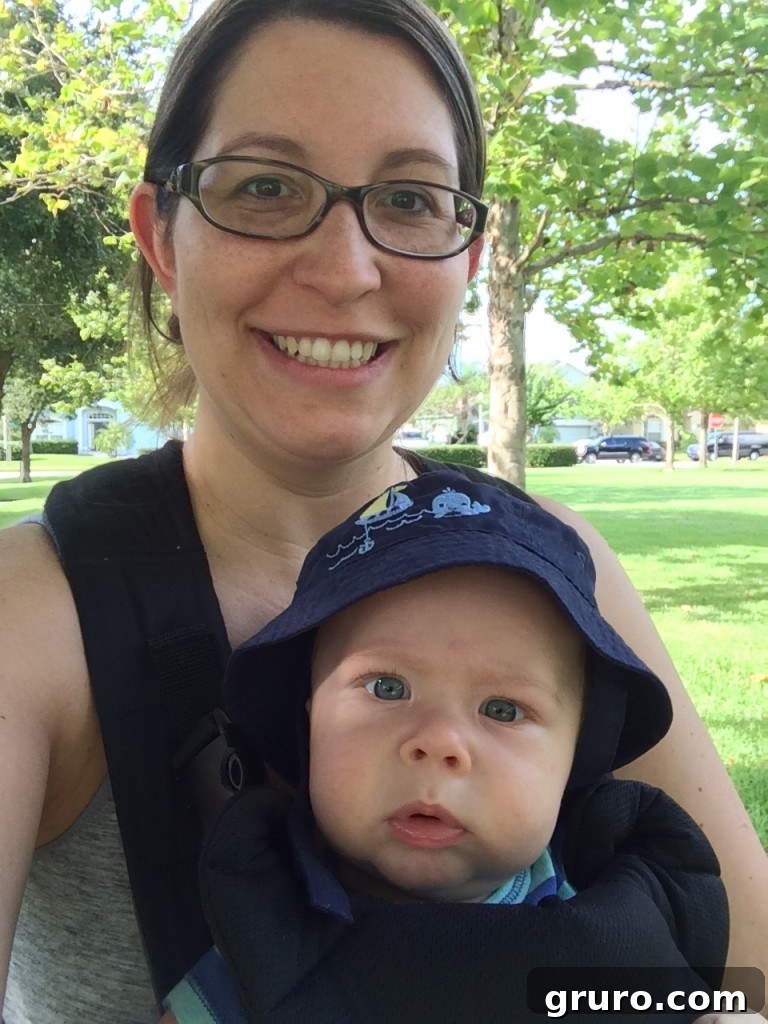 Mom babywearing Ryder while taking their dog Lola for a walk around the park