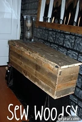 A rustic wooden coffin made from pallet wood, propped up in a yard for Halloween decoration.