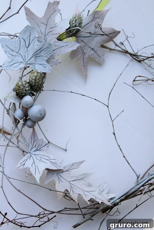 Wreath being spray painted with flat white paint, achieving a soft, frosted effect.