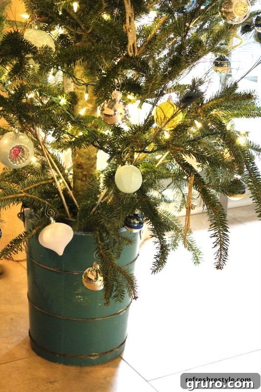 Rustic wooden ice cream churn with a small Christmas tree, decorated for the holidays in a farmhouse kitchen